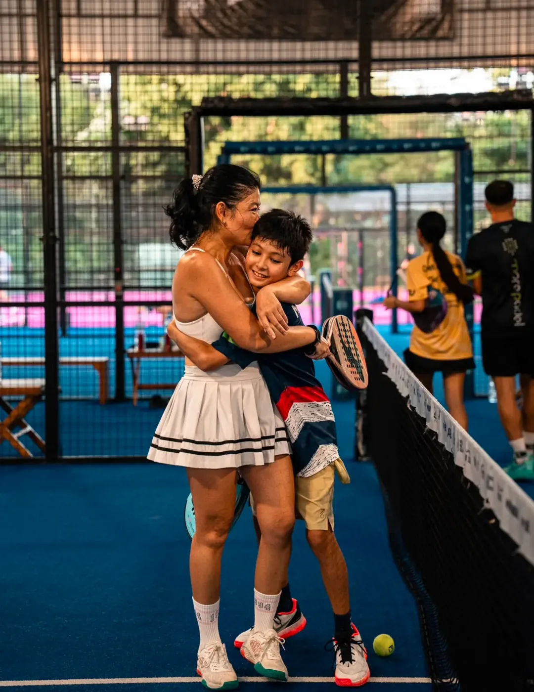 Mother hugging her son after a padel match at Padel Tropical Koh Samui