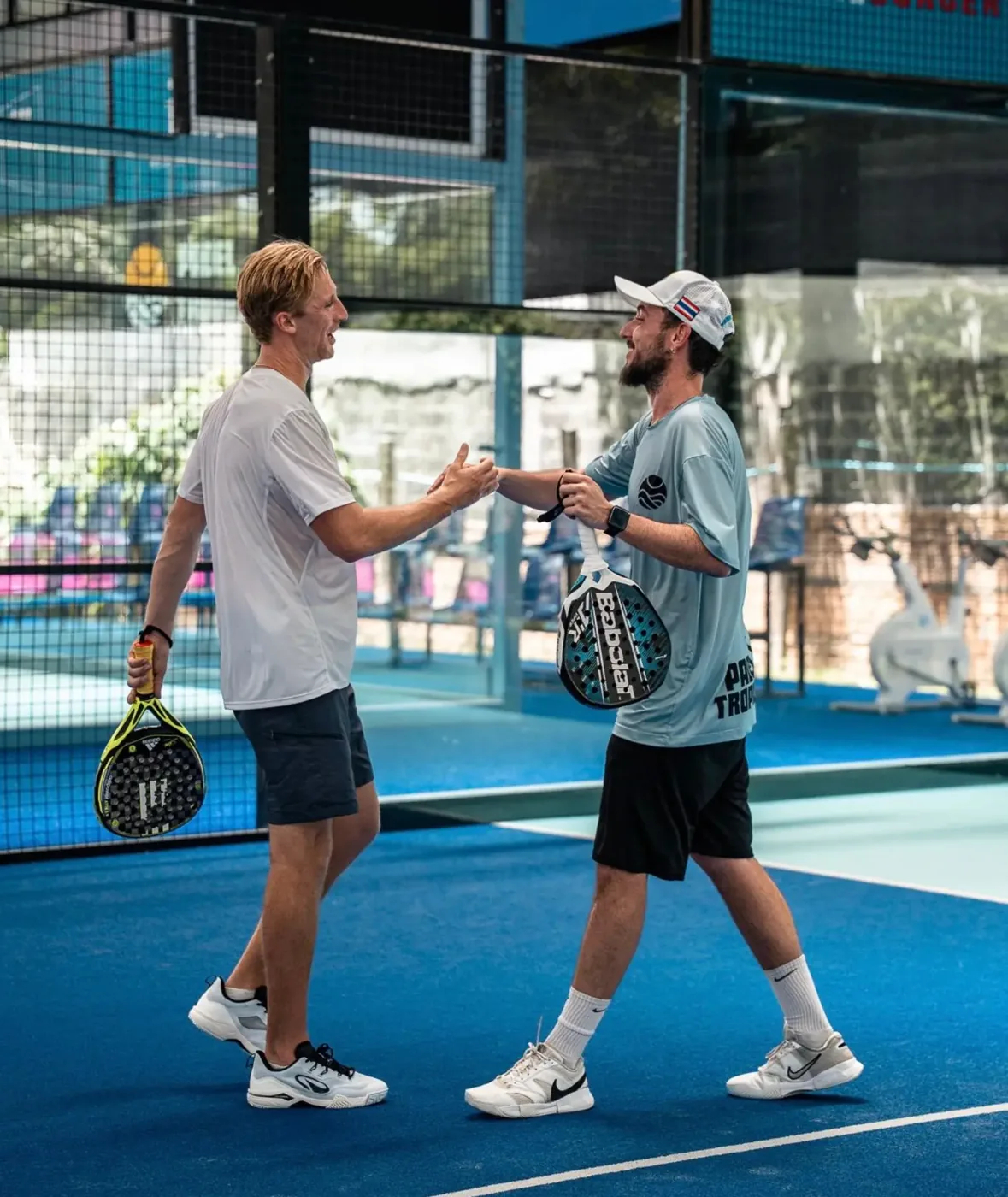 Two padel players shaking hands after a match at Padel Tropical